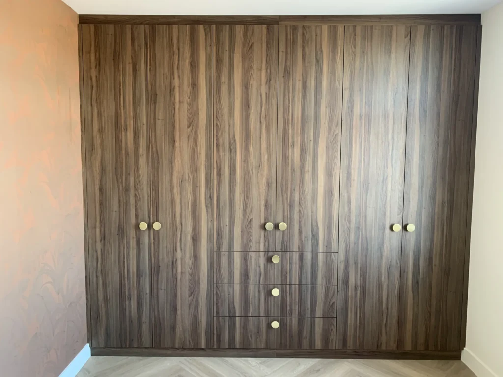Hoekkledingkast met messing knoppen in Boskoop, gemaakt en geplaatst door Koot Maatwerk